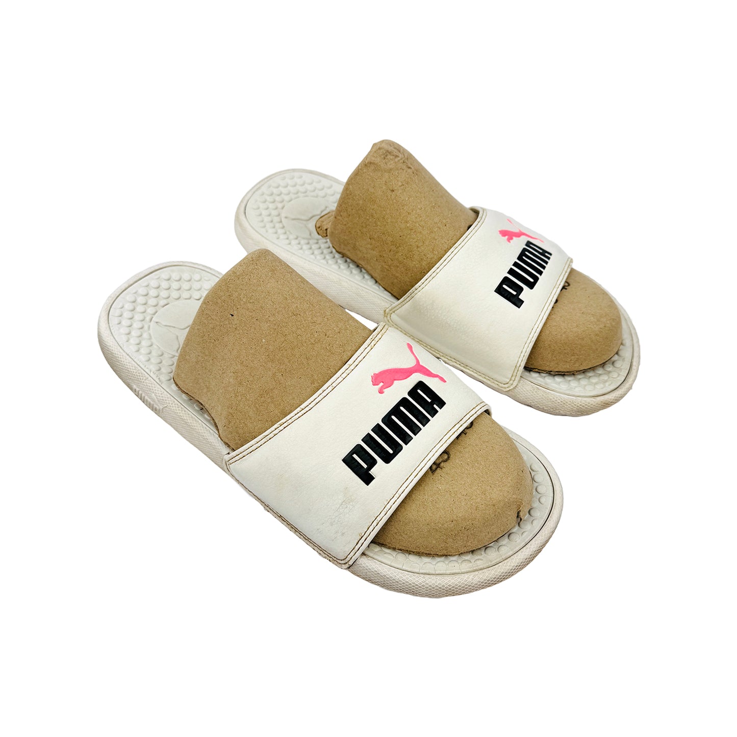 Pair of Puma slides with beige soles and white straps on a white background