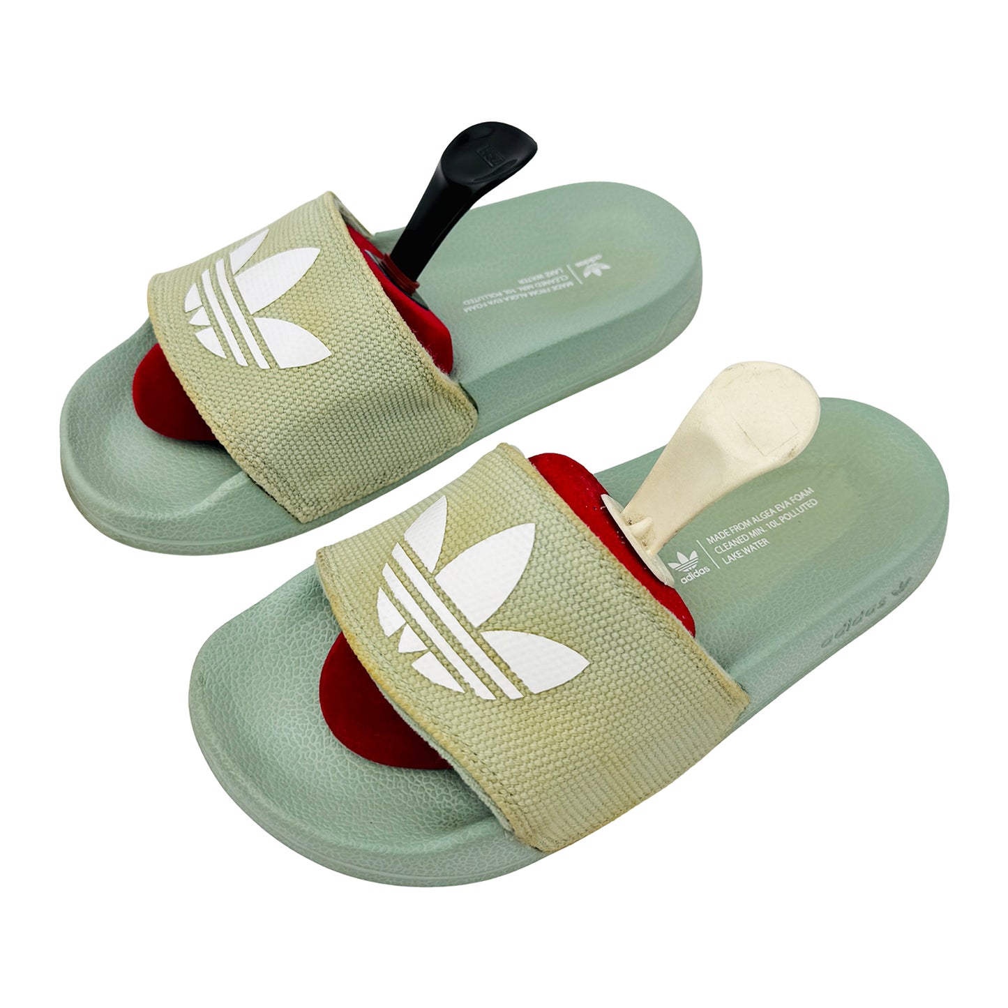 Pair of green adidas adilette slides with a white logo on a white background