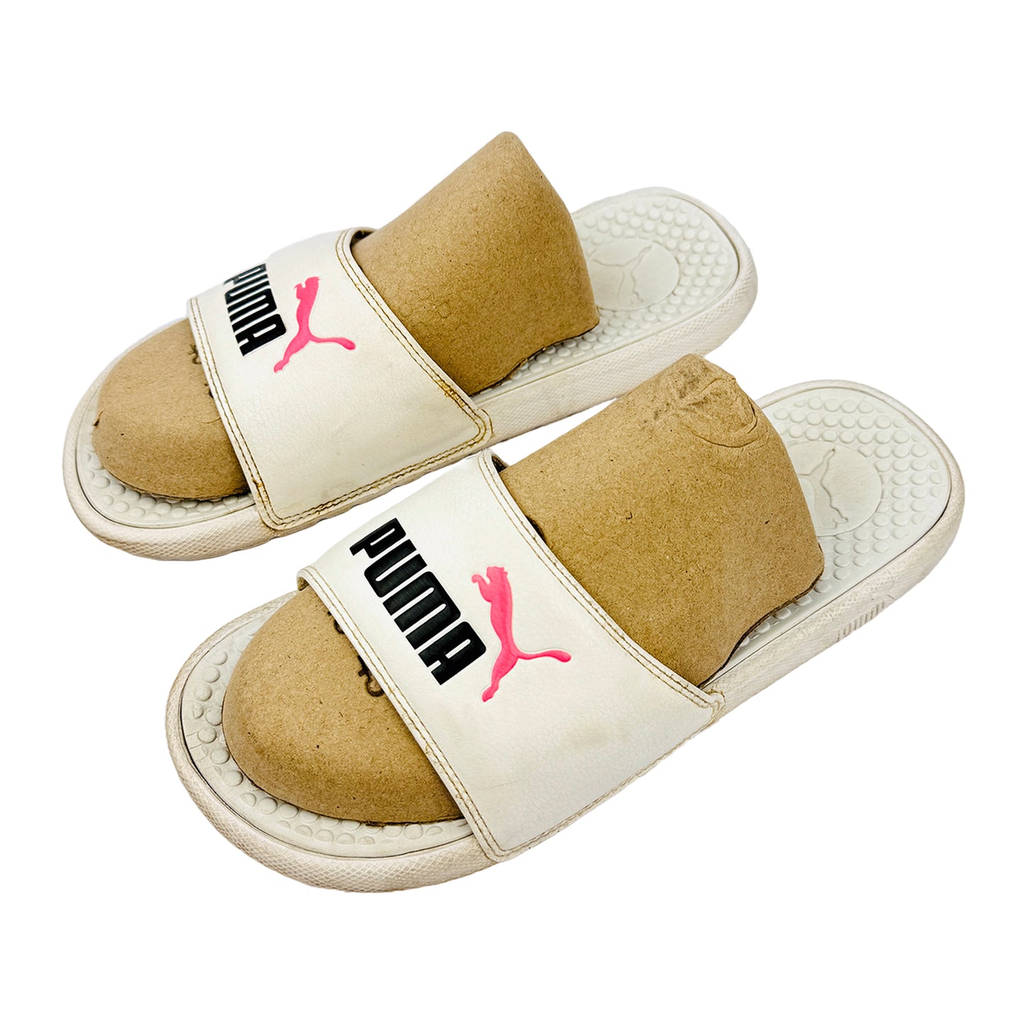 Pair of Puma slides with beige soles and white straps on a white background
