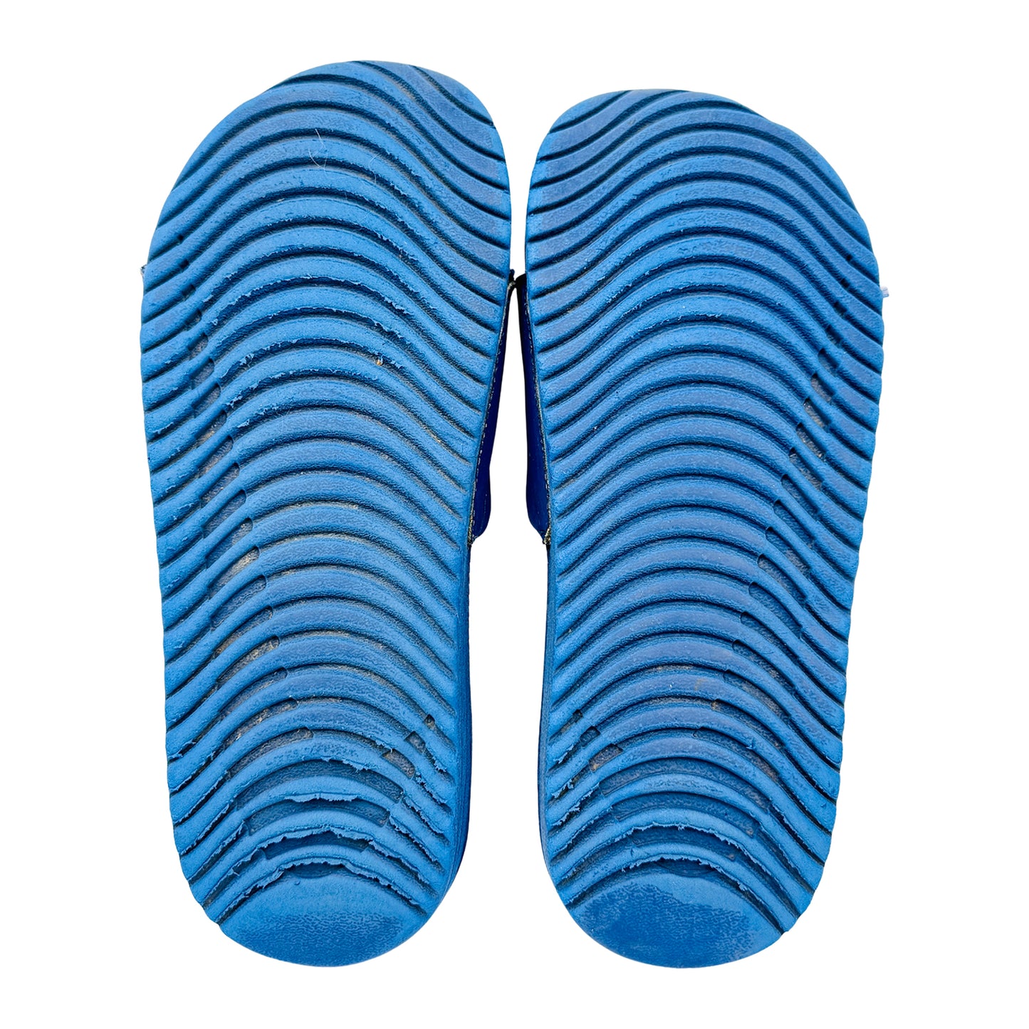 Blue nike kawa sildes outsole with textured pattern on a white background