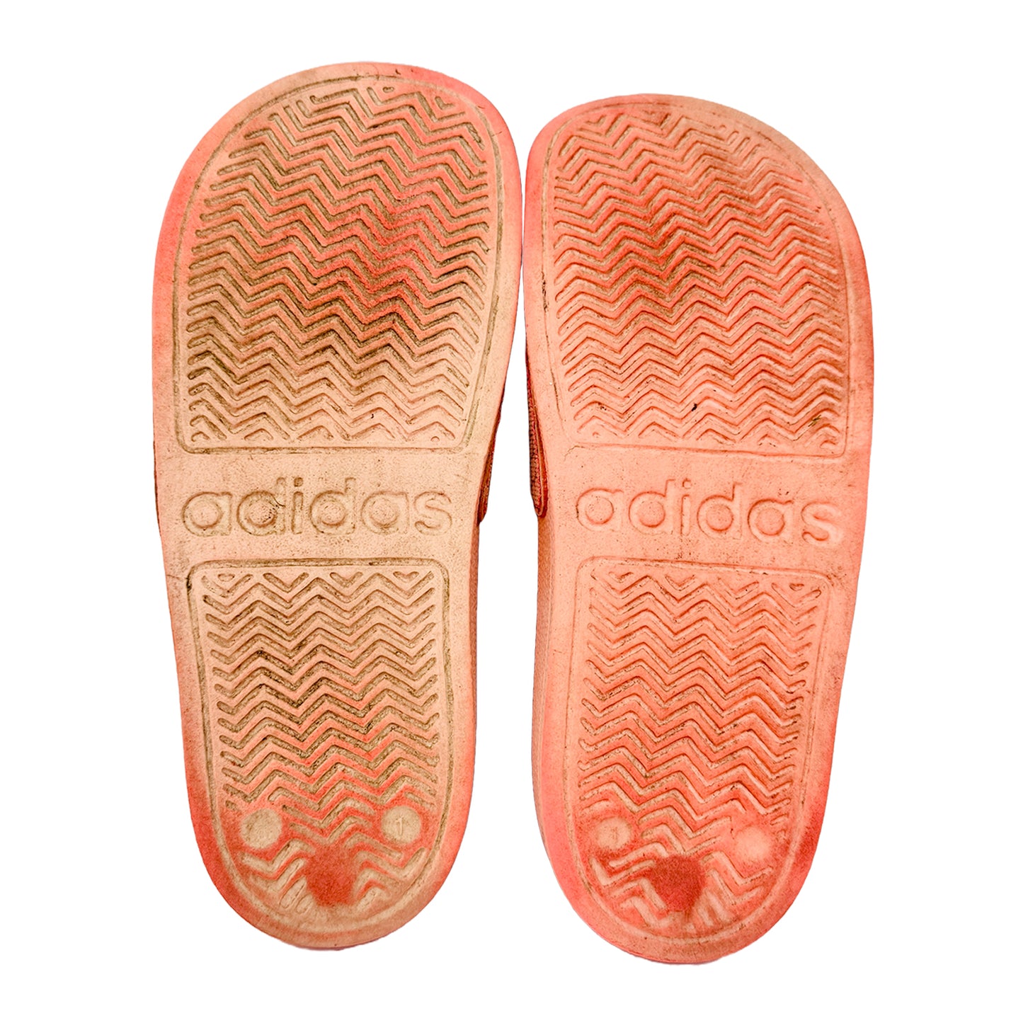 Adidas slippers with textured sole on a white background