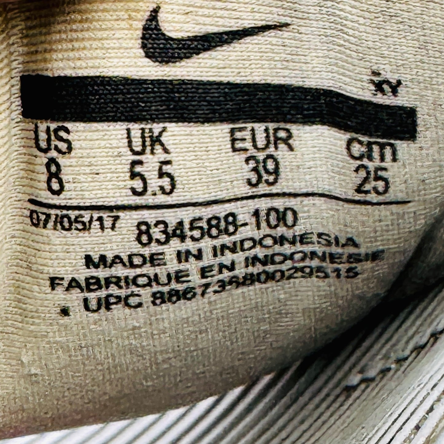 Close-up of a Nike kawa slide label with size, code 834588-100 and manufacturing details