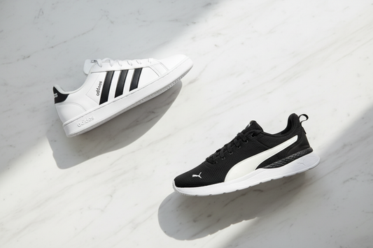 Two sneakers arranged diagonally on a white marble surface in a premium flat lay