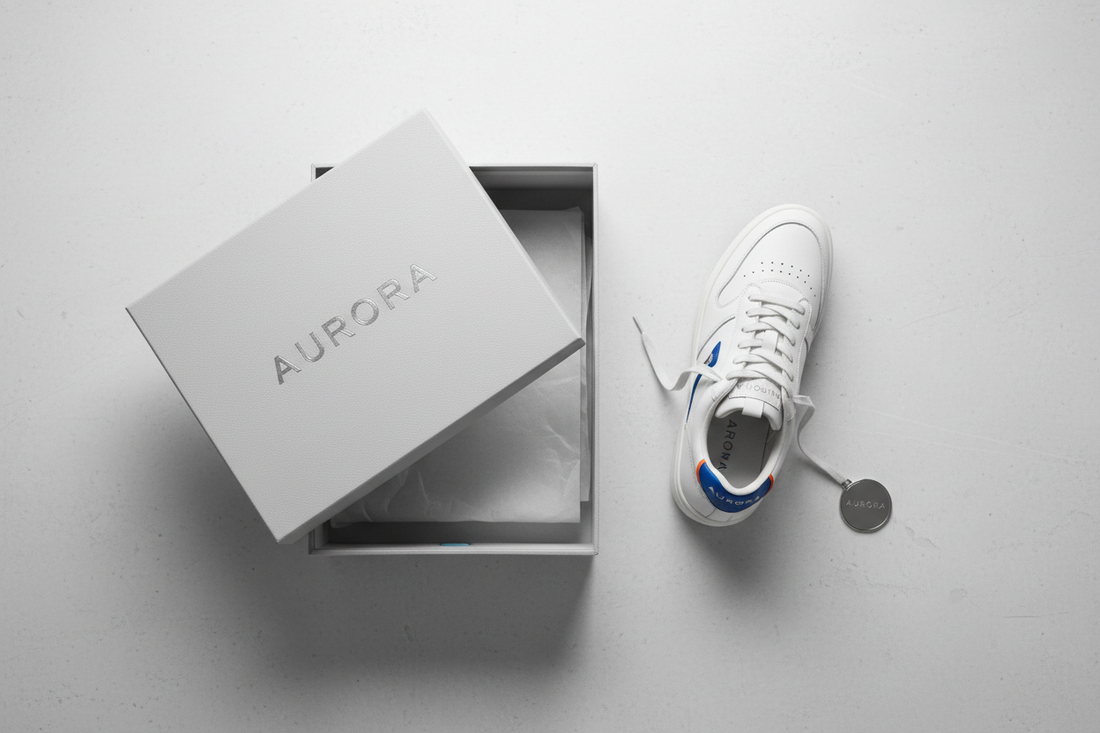 Branded sneaker placed next to its box on a clean surface for authenticity verification
