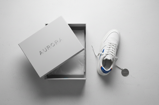 Branded sneaker placed next to its box on a clean surface for authenticity verification