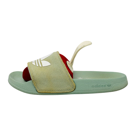 Green Adidas Adilette Slides with a textured strap on a white background