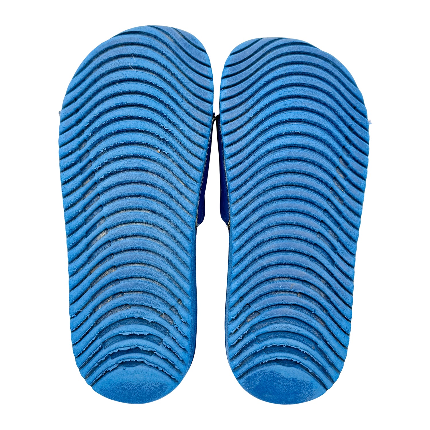 Blue nike kawa sildes outsole with textured pattern on a white background